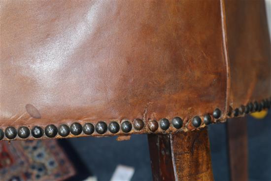 A George III mahogany hide-covered wing chair